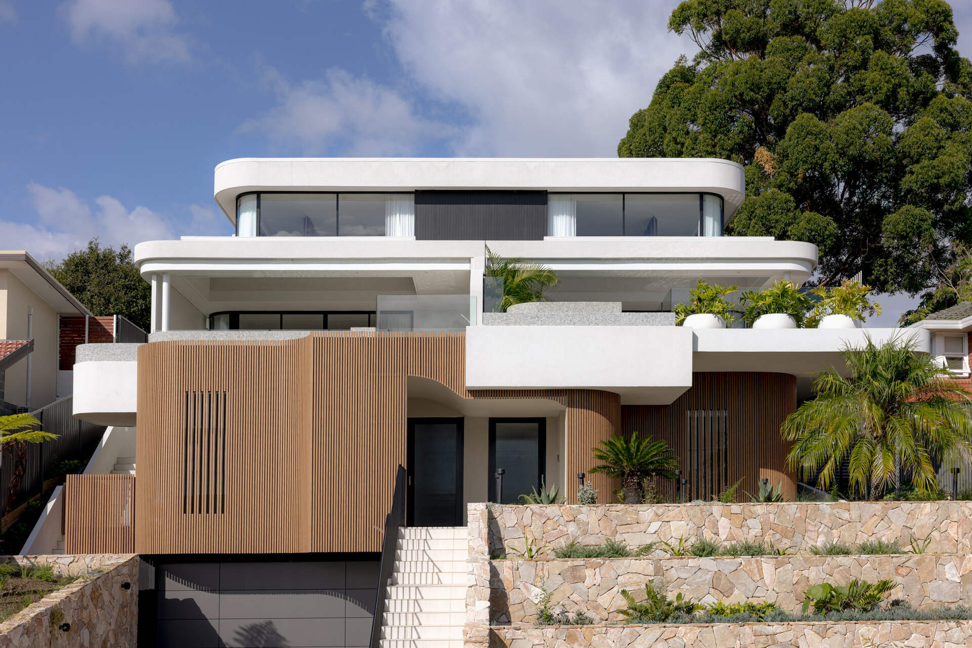 A modern home with wood details and curves on the facade.