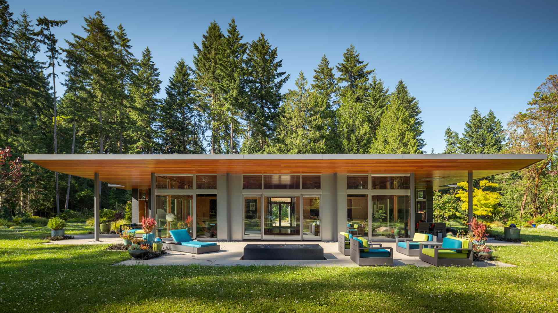 A single tapered roof ties together this home, carriage house, and sauna creating a generous covered entry promenade.