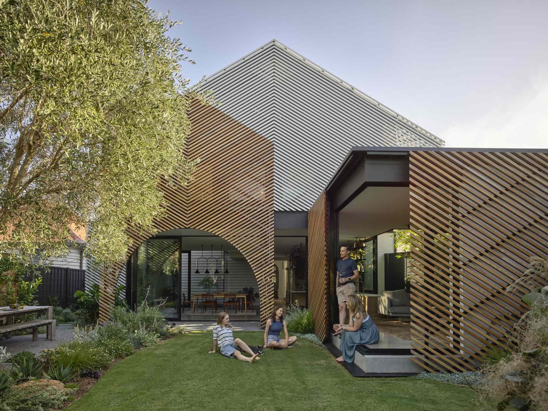 A batten screen was used to unify the rear extension with the original home, bringing together the addition in a simple meeting of forms, while providing shade and protection, restricting overlooking, and creating a covered verandah.