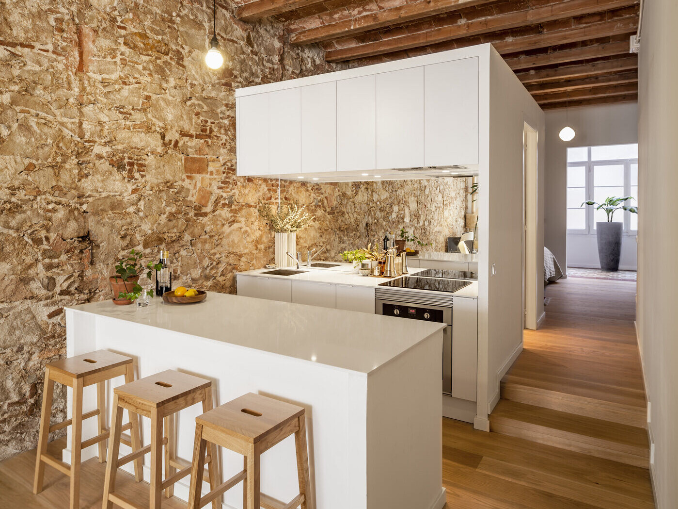 A serene, Japanese-inspired Barcelona apartment that blends stone walls, natural oak, soft light, and open-plan living.