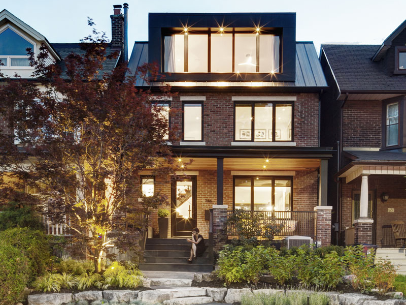 Modern dormers with deep overhangs refresh this Toronto home’s facade, while layered landscaping adds curb appeal and charm.
