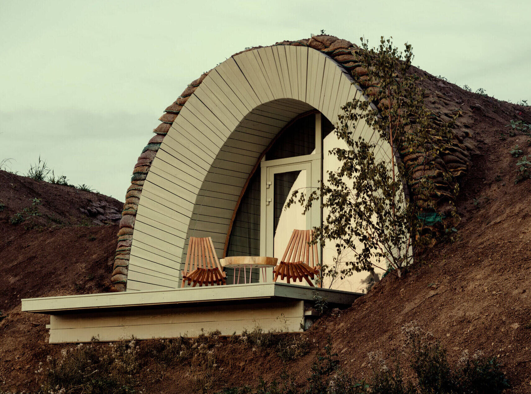 Hobbit-inspired cabins built-into the earth, includes a bedroom, kitchen, and bathroom.