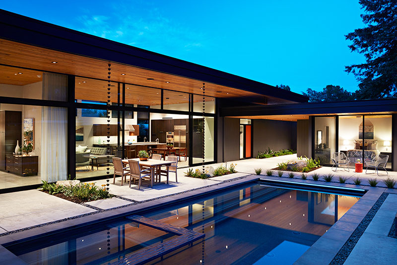 A mid-century modern inspired home with open interiors and a swimming pool.