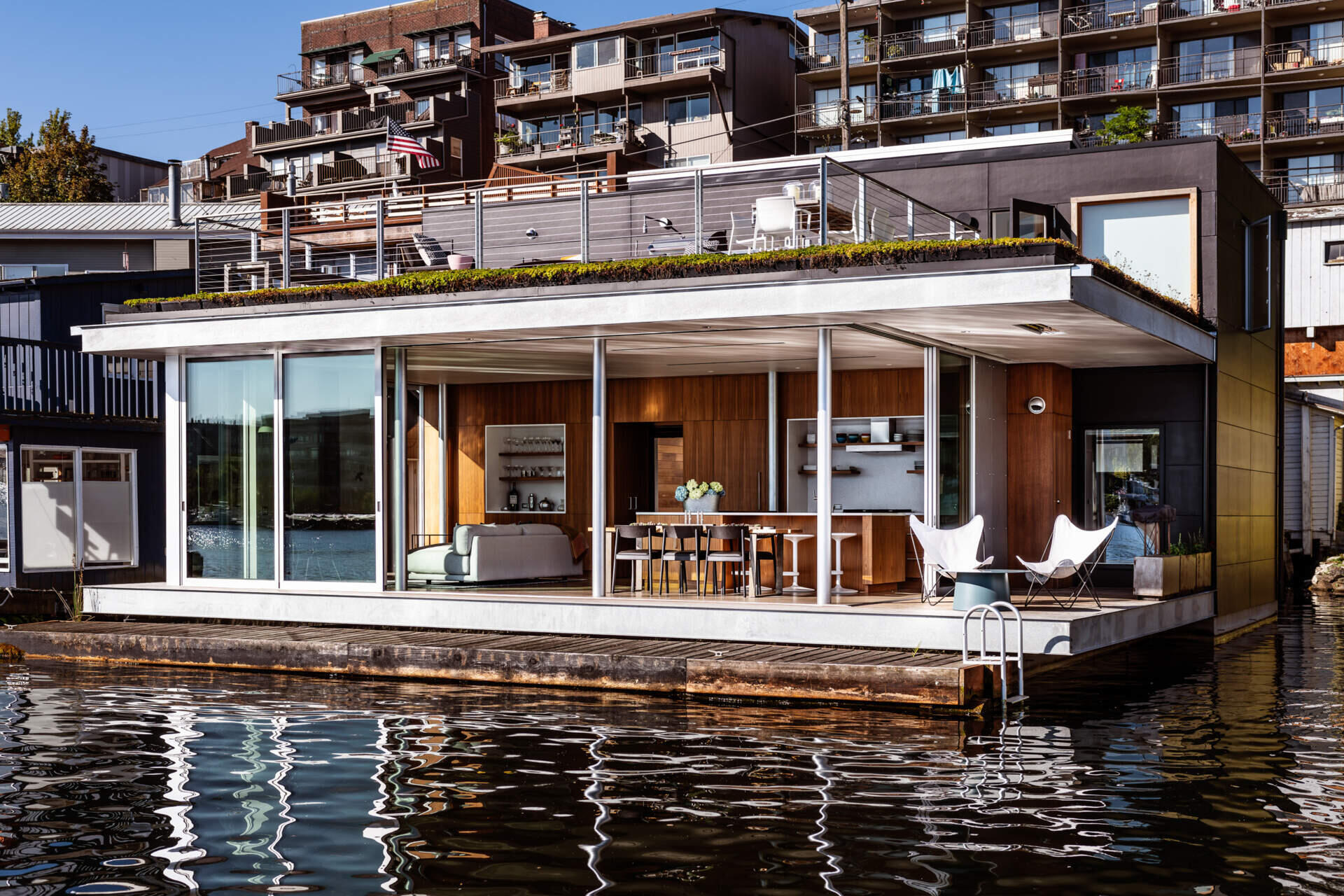 This modern floating home blends simplicity, water views, and flexible spaces with a rooftop deck and green roof.