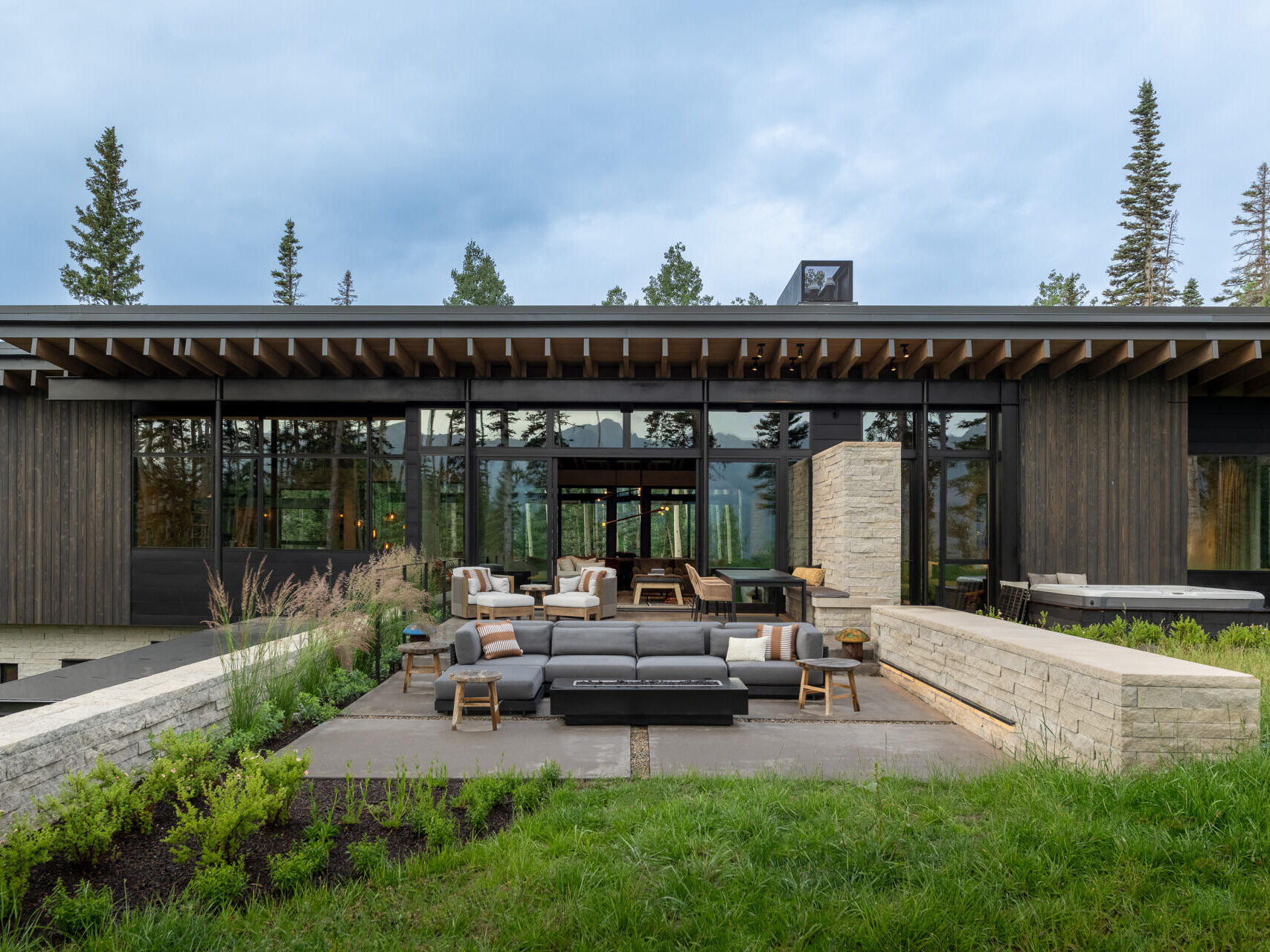 Rough sawn cedar, limestone, and steel ground this modern home in its wooded setting.