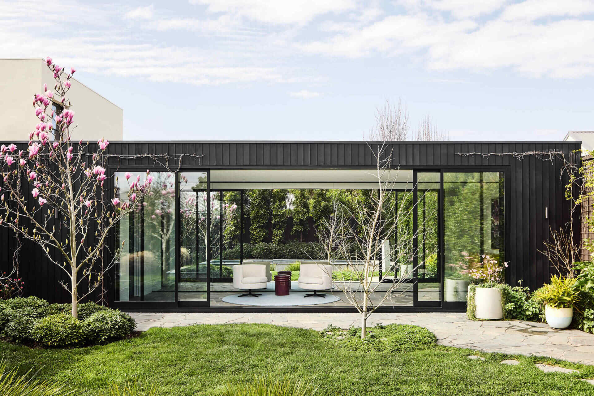 This Melbourne residence combines a restored Victorian facade with dark timber and glass for a seamless modern contrast.